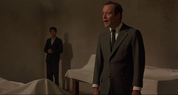 Movie still from “Avanti!” (1972), directed by Billy Wilder – A man in a suit and tie standing next to another man in a suit and tie; Medium shot, Low angle