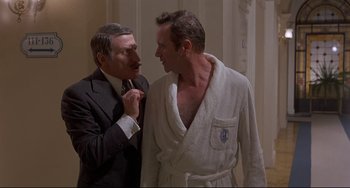 Movie still from “Avanti!” (1972), directed by Billy Wilder – Two men standing next to each other in a room; Medium shot, Over the shoulder angle