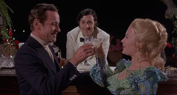 Movie still from “Avanti!” (1972), directed by Billy Wilder – A group of people sitting at a table drinking wine; Medium shot, High angle