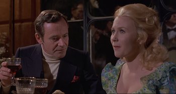 Movie still from “Avanti!” (1972), directed by Billy Wilder – A man and a woman sitting next to each other at a table; Close Up shot, Low angle