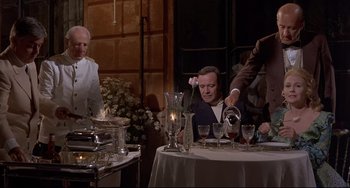 Movie still from “Avanti!” (1972), directed by Billy Wilder – A group of people sitting at a table with wine glasses; Medium shot, Low angle