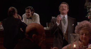 Movie still from “Avanti!” (1972), directed by Billy Wilder – A man in a suit and tie standing in front of another man in a suit and tie in front of a bar; Medium shot, Over the shoulder angle