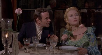Movie still from “Avanti!” (1972), directed by Billy Wilder – A man and a woman sitting at a dinner table; Medium shot, Over the shoulder angle