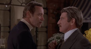 Movie still from “Avanti!” (1972), directed by Billy Wilder – Two men in suits talking to each other in front of a building; Close Up shot, Over the shoulder angle