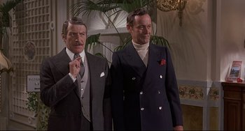 Movie still from “Avanti!” (1972), directed by Billy Wilder – Two men standing next to each other wearing suits; Medium shot, Low angle