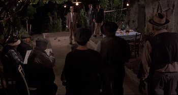 Movie still from “Avanti!” (1972), directed by Billy Wilder – A group of people standing around a table; Wide shot, High angle