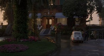 Movie still from “Avanti!” (1972), directed by Billy Wilder – A car parked in front of a house at night; Extreme Wide shot, Low angle