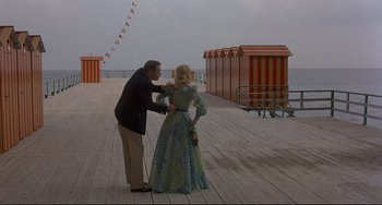 Movie still from “Avanti!” (1972), directed by Billy Wilder – A man and a woman on a boardwalk; Wide shot, Over the shoulder angle