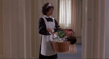 Movie still from “Avanti!” (1972), directed by Billy Wilder – A woman dressed as a maid holding a wicker basket; Medium shot, High angle