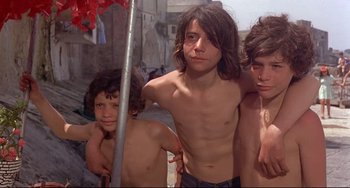 Movie still from “Avanti!” (1972), directed by Billy Wilder – A group of shirtless boys standing next to each other; Medium shot, Low angle