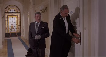 Movie still from “Avanti!” (1972), directed by Billy Wilder – Two men in suits and ties opening a door to a room; Medium shot, High angle