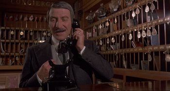Movie still from “Avanti!” (1972), directed by Billy Wilder – An older man in a suit talking on a phone; Close Up shot, Low angle