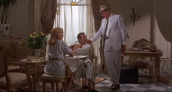 Movie still from “Avanti!” (1972), directed by Billy Wilder – A group of people sitting around a table; Wide shot, Over the shoulder angle