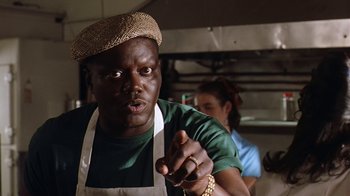 Movie still from “B*A*P*S” (1997), directed by Robert Townsend – A man wearing an apron and a hat is pointing; Close Up shot, Low angle
