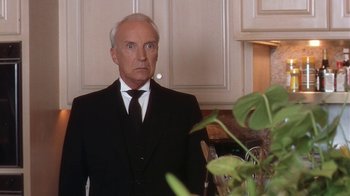 Movie still from “B*A*P*S” (1997), directed by Robert Townsend – An older man wearing a suit and tie in front of a plant; Close Up shot, Low angle