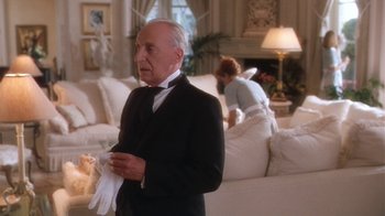 Movie still from “B*A*P*S” (1997), directed by Robert Townsend – An older man in a suit holding a white glove; Medium shot, Low angle