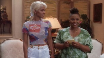 Movie still from “B*A*P*S” (1997), directed by Robert Townsend – Two women standing next to each other in front of a lamp; Medium shot, Low angle