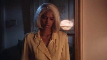 Movie still from “B*A*P*S” (1997), directed by Robert Townsend – A woman with white hair standing next to a window; Medium shot, Over the shoulder angle