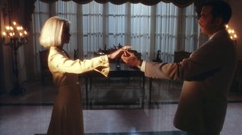 Movie still from “B*A*P*S” (1997), directed by Robert Townsend – A man and a woman holding hands in front of a window; Medium shot, Low angle