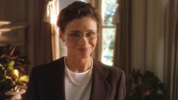 Movie still from “B*A*P*S” (1997), directed by Robert Townsend – A woman wearing glasses and a suit and pearl necklace; Close Up shot, High angle