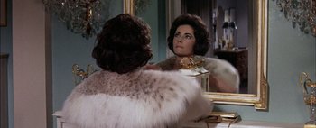Movie still from “BUtterfield 8” (1960), directed by Daniel Mann – A woman looking in the mirror in front of a mirror; Close Up shot, Over the shoulder angle