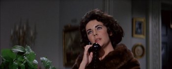 Movie still from “BUtterfield 8” (1960), directed by Daniel Mann – A woman talking on a phone while wearing a fur coat; Close Up shot, Low angle