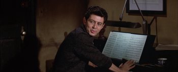 Movie still from “BUtterfield 8” (1960), directed by Daniel Mann – A man sitting in front of a sheet of music; Close Up shot, Low angle