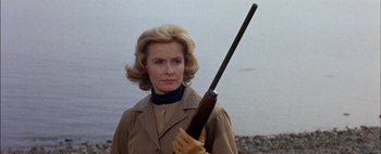 Movie still from “BUtterfield 8” (1960), directed by Daniel Mann – A woman holding a rifle in her hand; Close Up shot, Low angle
