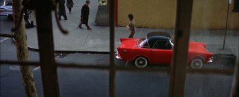 Movie still from “BUtterfield 8” (1960), directed by Daniel Mann – A red car parked on the side of the street; Wide shot, High angle