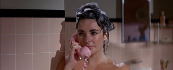 Movie still from “BUtterfield 8” (1960), directed by Daniel Mann – A woman in the shower talking on a phone; Close Up shot, High angle