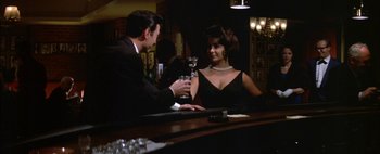 Movie still from “BUtterfield 8” (1960), directed by Daniel Mann – A man and a woman sitting at a bar holding wine glasses; Medium shot, Low angle