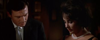 Movie still from “BUtterfield 8” (1960), directed by Daniel Mann – A woman in a black dress looking down at a man in a black suit; Close Up shot, Over the shoulder angle