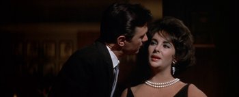 Movie still from “BUtterfield 8” (1960), directed by Daniel Mann – A man and a woman in formal wear with pearls; Close Up shot, Over the shoulder angle