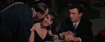 Movie still from “BUtterfield 8” (1960), directed by Daniel Mann – A man and a woman sitting at a table with two other men; Close Up shot, Over the shoulder angle