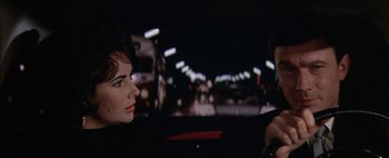 Movie still from “BUtterfield 8” (1960), directed by Daniel Mann – A woman sitting in the driver's seat of a car at night; Close Up shot, Over the shoulder angle
