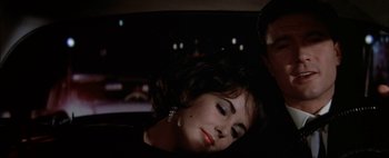 Movie still from “BUtterfield 8” (1960), directed by Daniel Mann – A woman in a black dress in the back seat of a car; Close Up shot, High angle