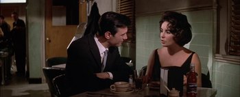 Movie still from “BUtterfield 8” (1960), directed by Daniel Mann – A man and a woman sitting at a table talking to each other; Medium shot, Over the shoulder angle