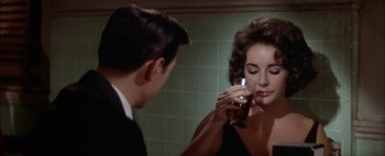 Movie still from “BUtterfield 8” (1960), directed by Daniel Mann – A man and a woman in a bathroom drinking a beer; Close Up shot, Over the shoulder angle