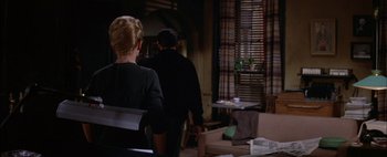 A man and a woman are walking in a room