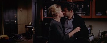 Movie still from “BUtterfield 8” (1960), directed by Daniel Mann – A man and a woman are kissing in a bar; Medium shot, Over the shoulder angle