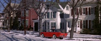 Movie still from “BUtterfield 8” (1960), directed by Daniel Mann – A red car parked in front of a white house; Extreme Wide shot, High angle