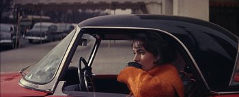 Movie still from “BUtterfield 8” (1960), directed by Daniel Mann – A woman sitting in the driver's seat of a car; Close Up shot, High angle