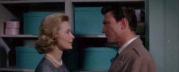 Movie still from “BUtterfield 8” (1960), directed by Daniel Mann – An older woman standing next to a younger man in a room; Close Up shot, Low angle