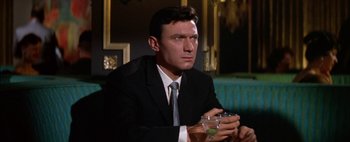 Movie still from “BUtterfield 8” (1960), directed by Daniel Mann – A man wearing a suit and tie holding a glass of wine; Close Up shot, Low angle