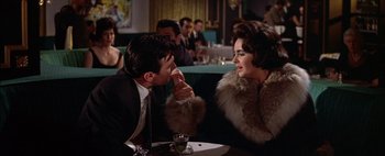 Movie still from “BUtterfield 8” (1960), directed by Daniel Mann – A man and a woman sitting at a table in front of each other; Medium shot, Over the shoulder angle