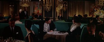 Movie still from “BUtterfield 8” (1960), directed by Daniel Mann – A man sitting at a table in front of a woman; Medium shot, High angle