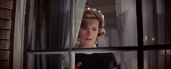 Movie still from “BUtterfield 8” (1960), directed by Daniel Mann – An older woman looking out of a window at night; Close Up shot, Low angle
