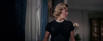 Movie still from “BUtterfield 8” (1960), directed by Daniel Mann – A woman in a black dress with a pearl necklace; Medium shot, Low angle