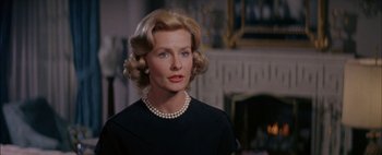 Movie still from “BUtterfield 8” (1960), directed by Daniel Mann – An older woman wearing a black dress and a pearl necklace; Close Up shot, Over the shoulder angle