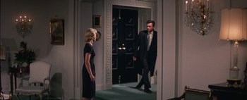 Movie still from “BUtterfield 8” (1960), directed by Daniel Mann – A man and a woman are walking in a doorway; Wide shot, Low angle